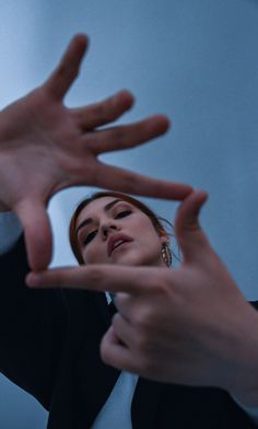 a woman is holding her hands up in the air while another person holds their hand out