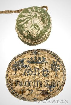 two old fashioned cloth balls with writing on them, one is green and the other is brown