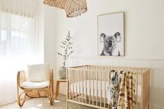 a baby's room with a crib, chair and pictures on the wall