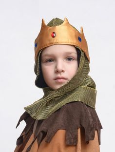 a young boy wearing a costume with a crown on his head and scarf around his neck