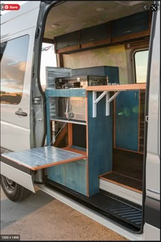 an open white van with its door open and shelves on the side, sitting in a parking lot