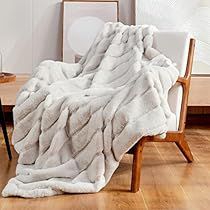 a white blanket sitting on top of a wooden chair