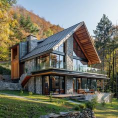 a modern house in the mountains with stone walls and windows on each side, surrounded by trees