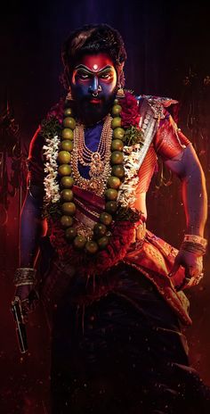 a man dressed in an elaborate costume with beads on his neck and chest, standing against a dark background