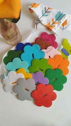 a bunch of wooden flowers sitting on top of a white table next to a vase