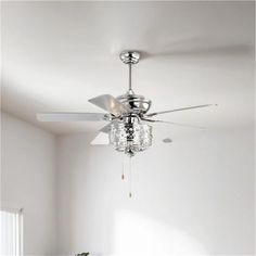 a ceiling fan in a white room with chandelier