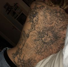 the back of a woman's body with tattoos on it