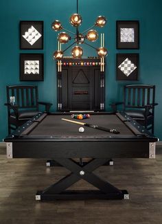 a pool table in the middle of a room with chairs and pictures on the wall