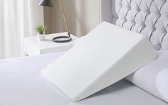 a bed with a white pillow on top of it