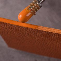 an orange object being used to paint the surface