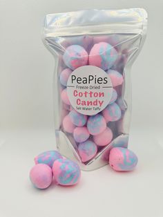 pink and blue candy candies in a bag on a white surface with the words, peepies cotton candy