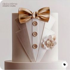 there is a white cake with gold bow ties on it and an image of a tuxedo