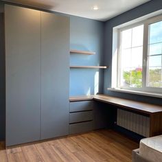 an empty room with blue walls and wooden floors