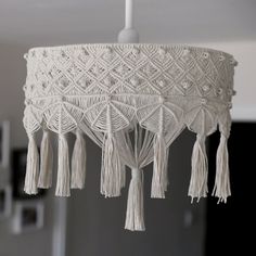 a white chandelier with tassels hanging from it