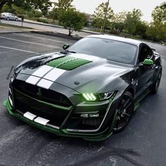 a green and white mustang parked in a parking lot