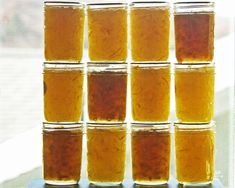 several jars filled with liquid sitting on top of a counter next to a window sill