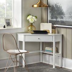 a white desk with a chair next to it and a painting hanging on the wall