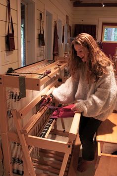 a woman is working on a weaving machine