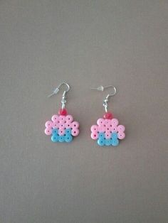 two pink and blue earrings on a gray surface