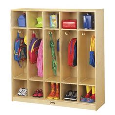 a child's wooden locker with many coats and shoes