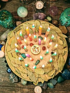 a decorative plate with lit candles on it surrounded by rocks and other items such as stones