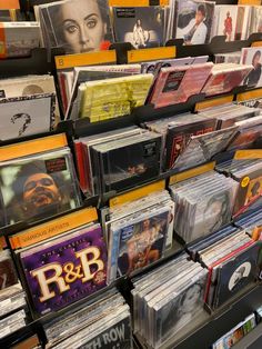 many cd's are stacked on top of each other in a store display case