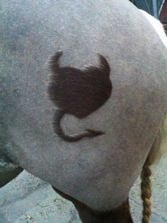 a close up of a horse's head with a long braid on it and a cat drawn on the back of its head