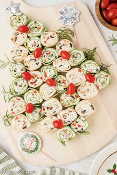 a christmas tree shaped appetizer on a cutting board next to other holiday food