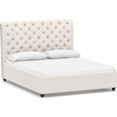 a white bed with an upholstered headboard