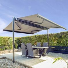 an outdoor dining area with table, chairs and umbrella on the side of the deck