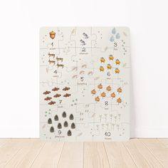 a puzzle board with animals on it sitting on a wooden floor next to a wall