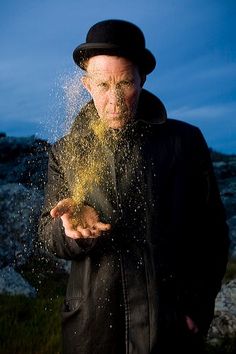 a man in a black jacket and hat sprinkled with sand