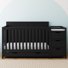 a black crib in front of a blue wall