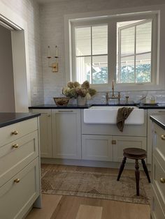 a kitchen with white cabinets and black counter tops