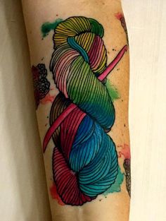 a woman's arm with a colorful yarn tattoo on it