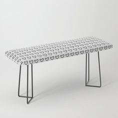 a white table with hearts on it and black metal legs, against a gray background