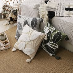 pillows and blankets on the floor next to a basket with an empty cup in it