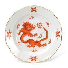 an orange and white plate with a dragon on it