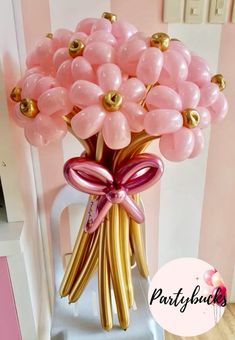 a vase filled with pink and gold balloons