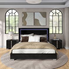 a large bed sitting in the middle of a bedroom next to two tall arched windows