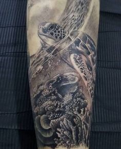 a man's arm with a turtle and seaweed tattoo design on the sleeve