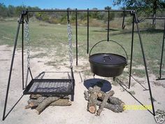 an empty swing set with a pot and pan on the ground in front of it