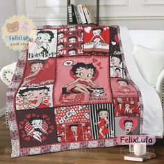 a bed with a red and black quilt on it's cover, next to a white chair