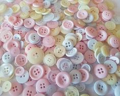 a pile of pink and white buttons sitting on top of a table