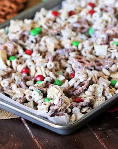 a pan filled with cereal and candy on top of a wooden table