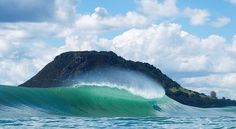 a large wave is coming towards an island in the ocean