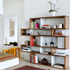 a living room filled with furniture and bookshelves on top of eachother