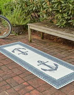 a blue and white rug with an anchor on it