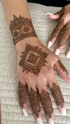 two hands with henna tattoos on them