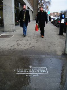 two men walking down the street with shopping bags